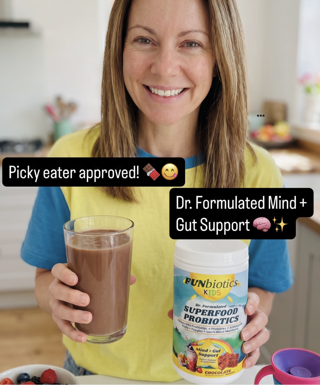A smiling woman in a kitchen holds a glass of chocolate-colored drink and a tub of Funbiotics Kids Superfood Probiotics. Text overlays read 'Picky eater approved!' and 'Dr.